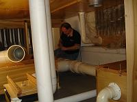  From the blower, air is piped to boxes called reservoirs, which maintain a constant air pressure. From the reservoirs the air is piped to the windchests, long flat wooden boxes with holes in which the pipes rest. In the two side chambers the wind chests take up most of the space, so the reservoirs are located in the cramped space underneath.